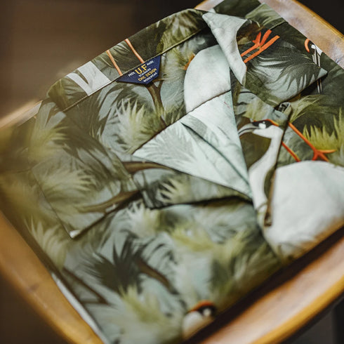 Tropical patterned shirt with a brand label on a wooden surface